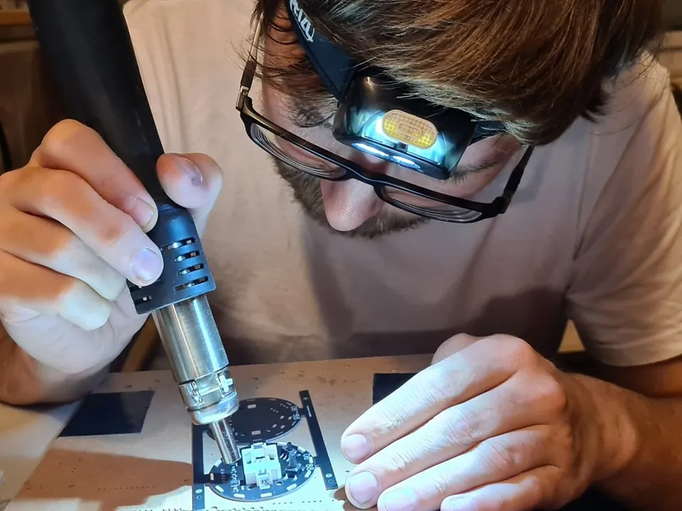 Simon lötet mit Heißluft ein Bauteil auf eine Platine